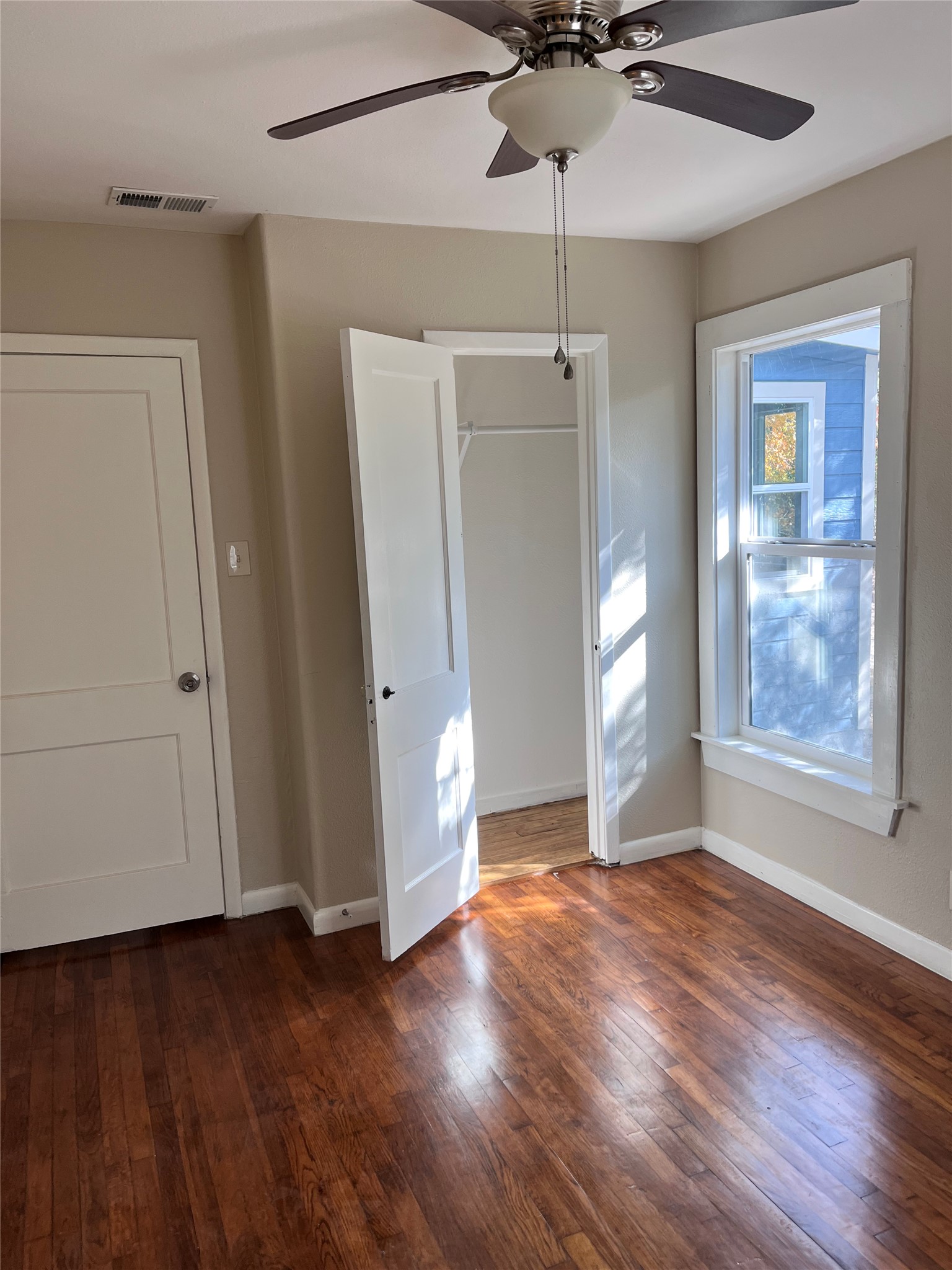 1565 Pump Station Road, Unit B Wimberley, TX 78676 - Photo 2 of 12 Unfurnished bedroom featuring dark wood-style floors and ceiling fan