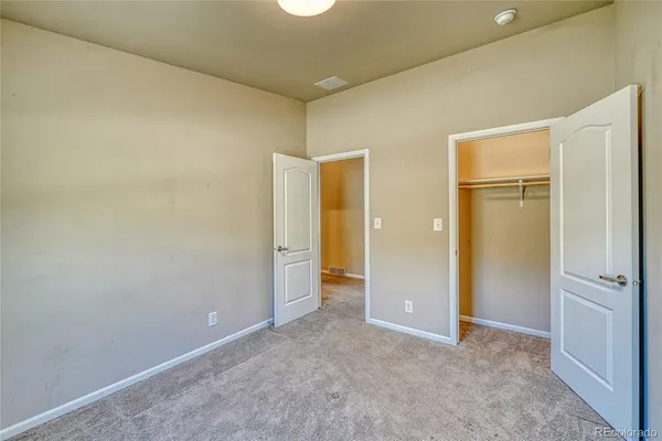 an empty room with windows and closet