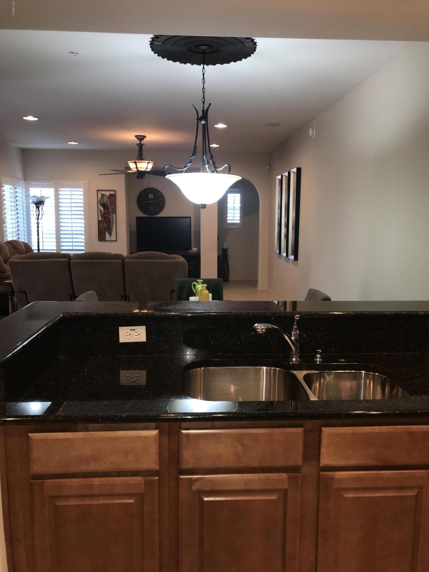 3935 East Rough Rider Road, Unit 1385 Phoenix, AZ 85050 - Photo 6 of 14 a kitchen with a sink and chandelier