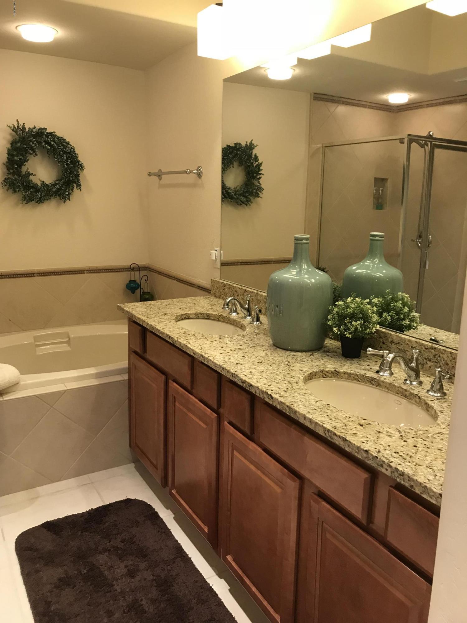 3935 East Rough Rider Road, Unit 1385 Phoenix, AZ 85050 - Photo 8 of 14 a bathroom with a granite countertop sink and a mirror