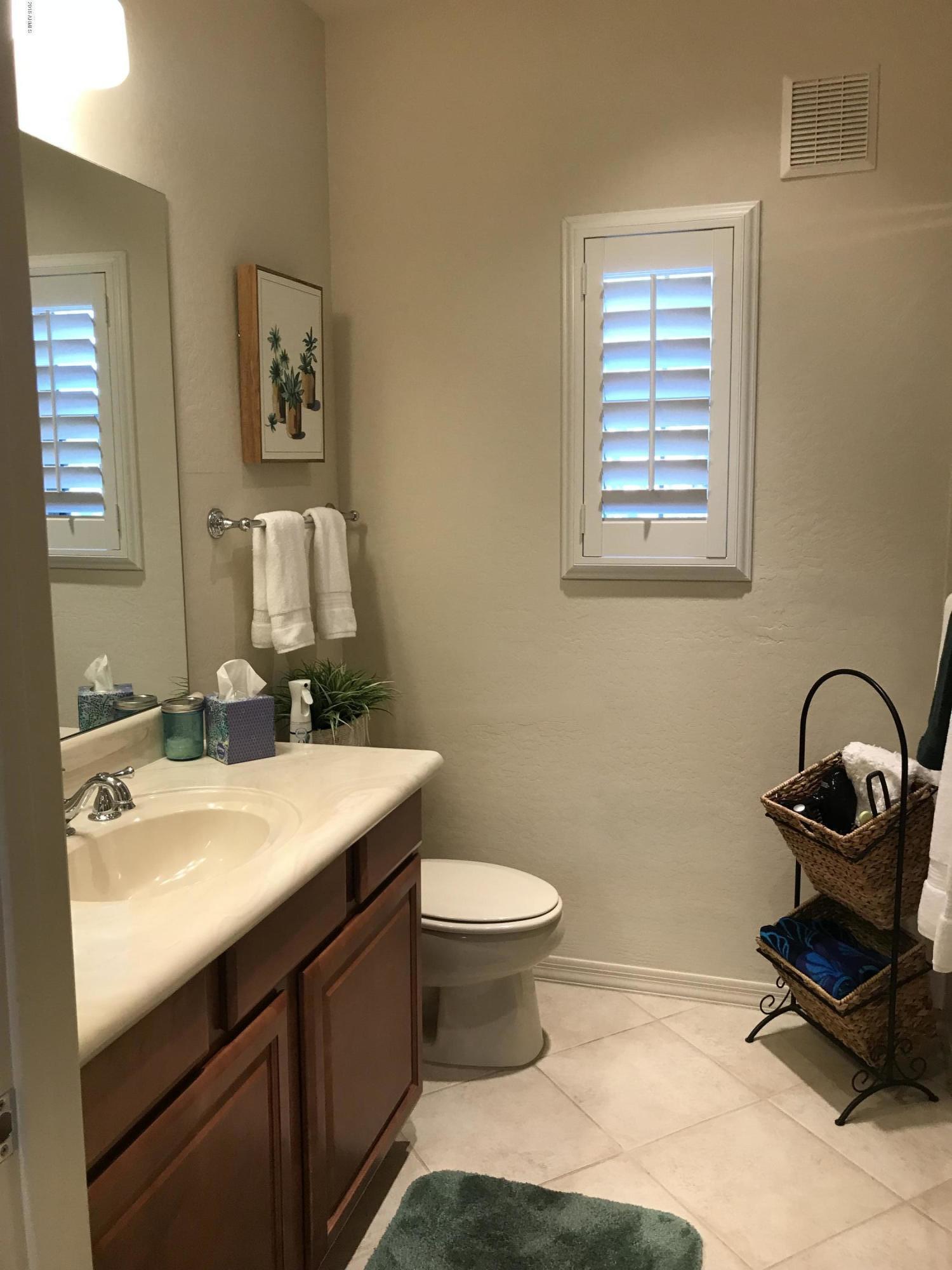 3935 East Rough Rider Road, Unit 1385 Phoenix, AZ 85050 - Photo 10 of 14 a bathroom with a sink toilet and a mirror