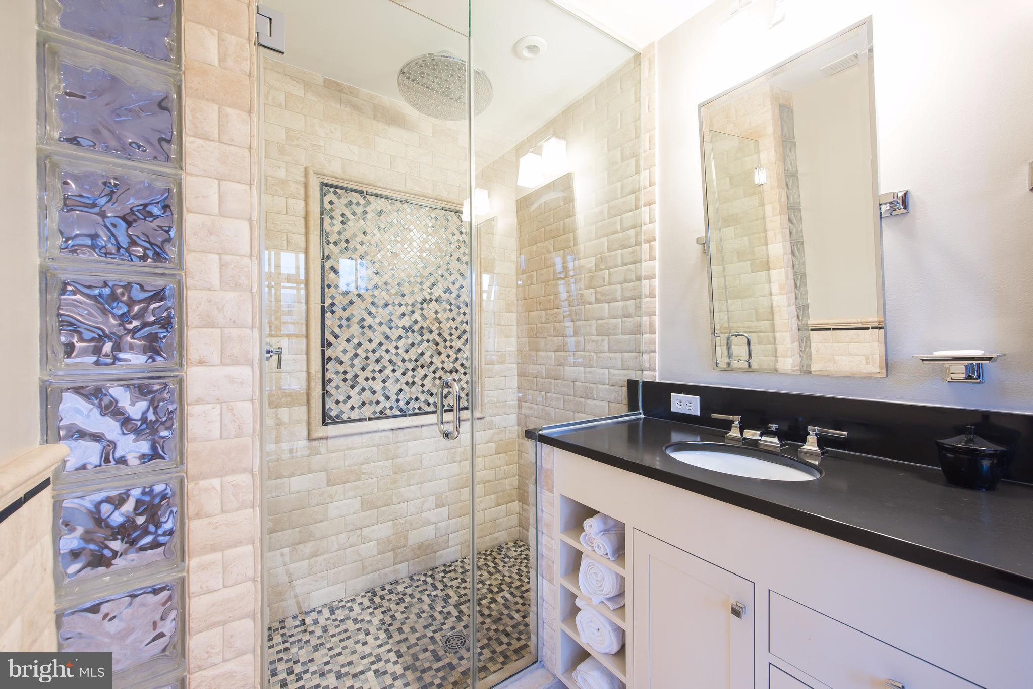 1016 Massachusetts Avenue Northeast Washington, DC 20002 - Photo 20 of 28 a bathroom with a granite countertop sink a large mirror and a shower