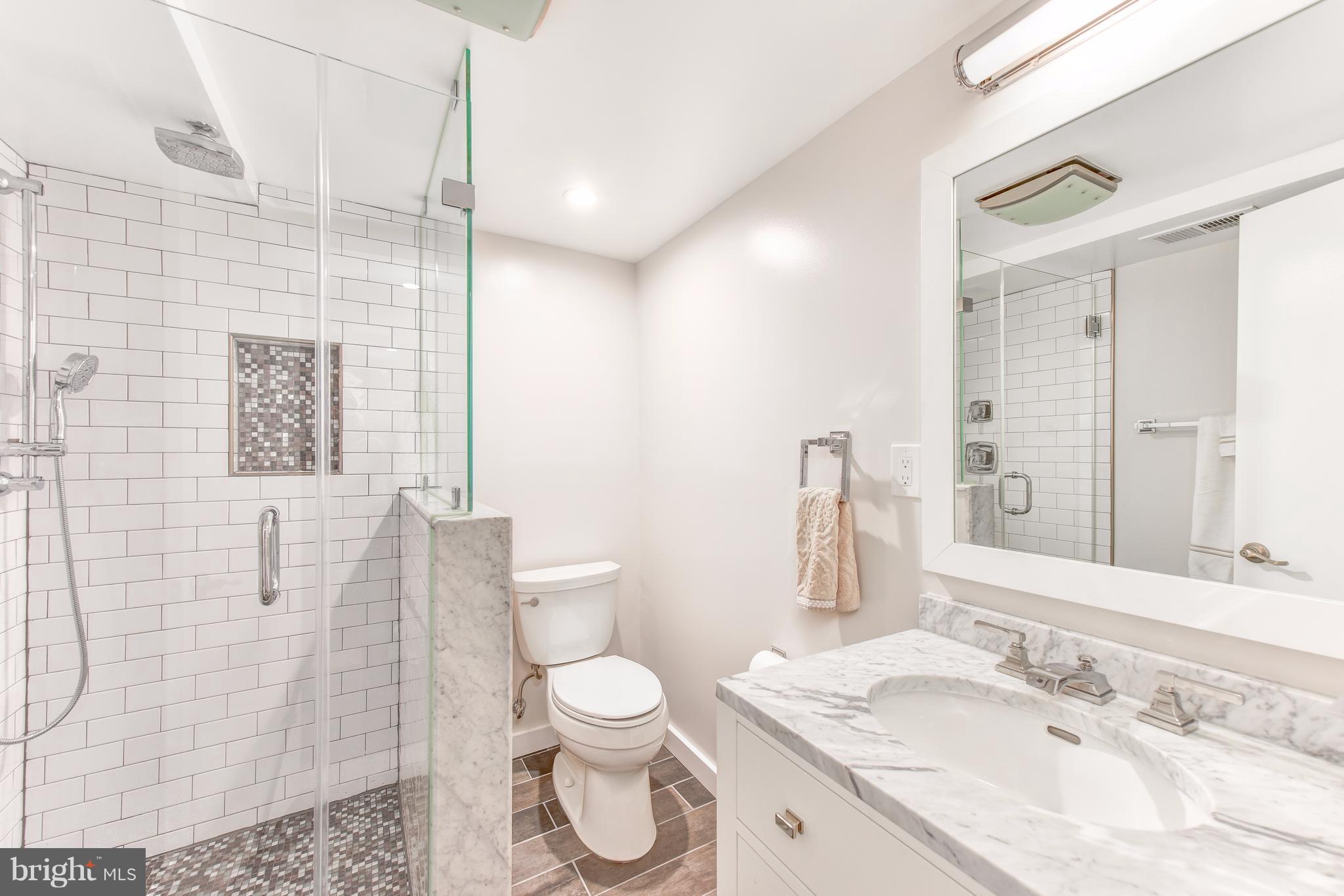 1016 Massachusetts Avenue Northeast Washington, DC 20002 - Photo 26 of 28 a bathroom with a granite countertop sink a toilet and a mirror