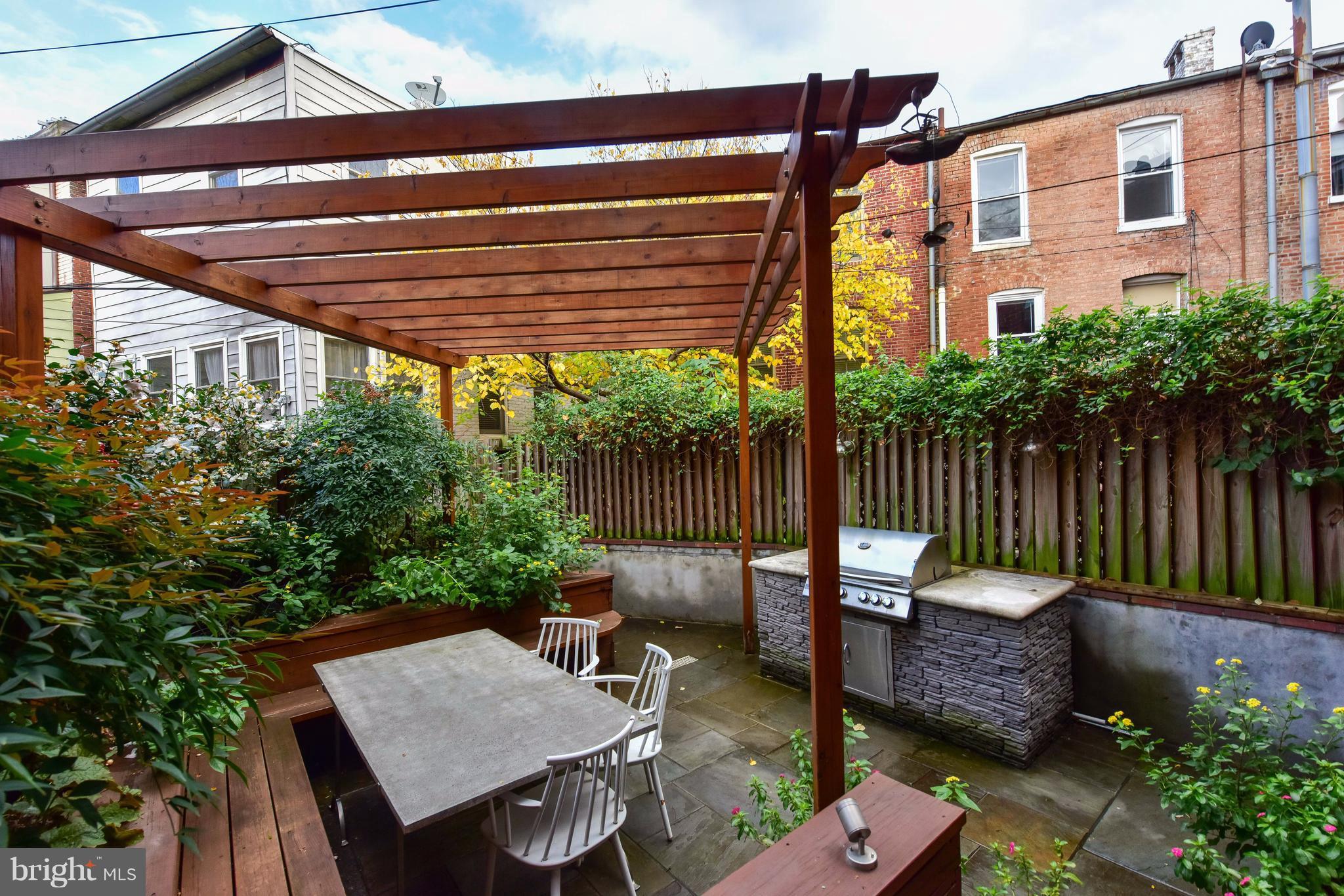 1016 Massachusetts Avenue Northeast Washington, DC 20002 - Photo 27 of 28 a view of a patio with table and chairs potted plants and wooden fence