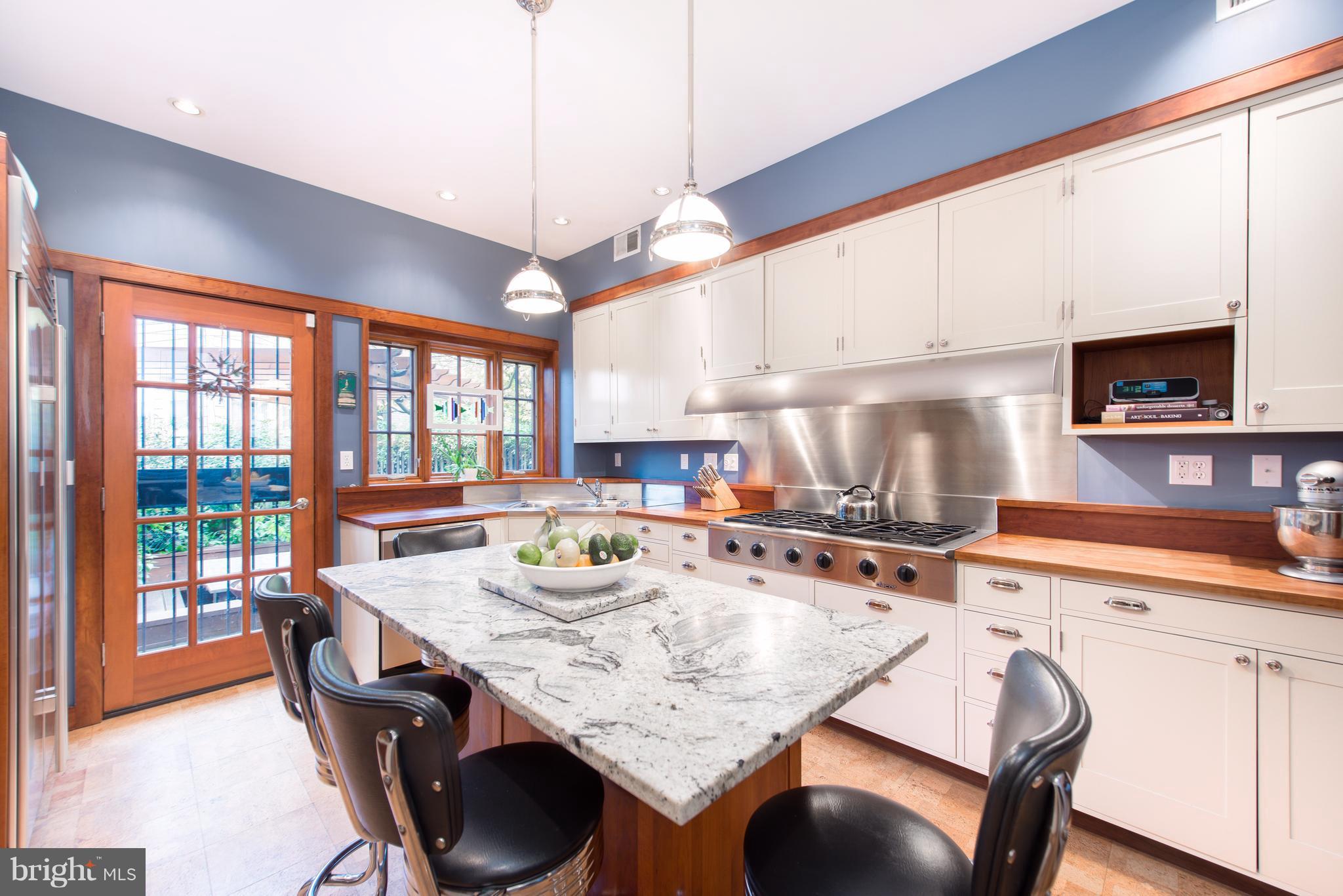 1016 Massachusetts Avenue Northeast Washington, DC 20002 - Photo 7 of 28 a kitchen with stainless steel appliances granite countertop a stove a sink a microwave dining table and chairs