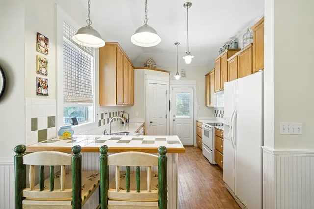 a kitchen with stainless steel appliances granite countertop a sink and cabinets with wooden floor