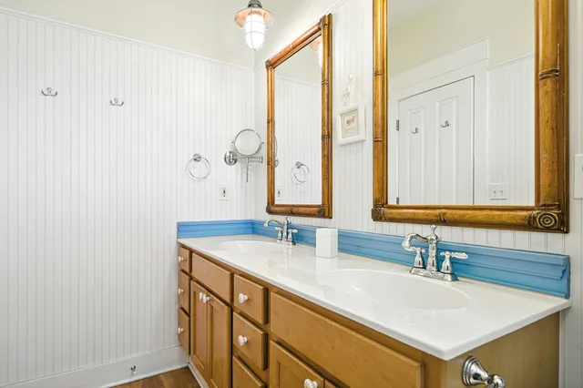 a bedroom with a bed a chandelier and a dresser