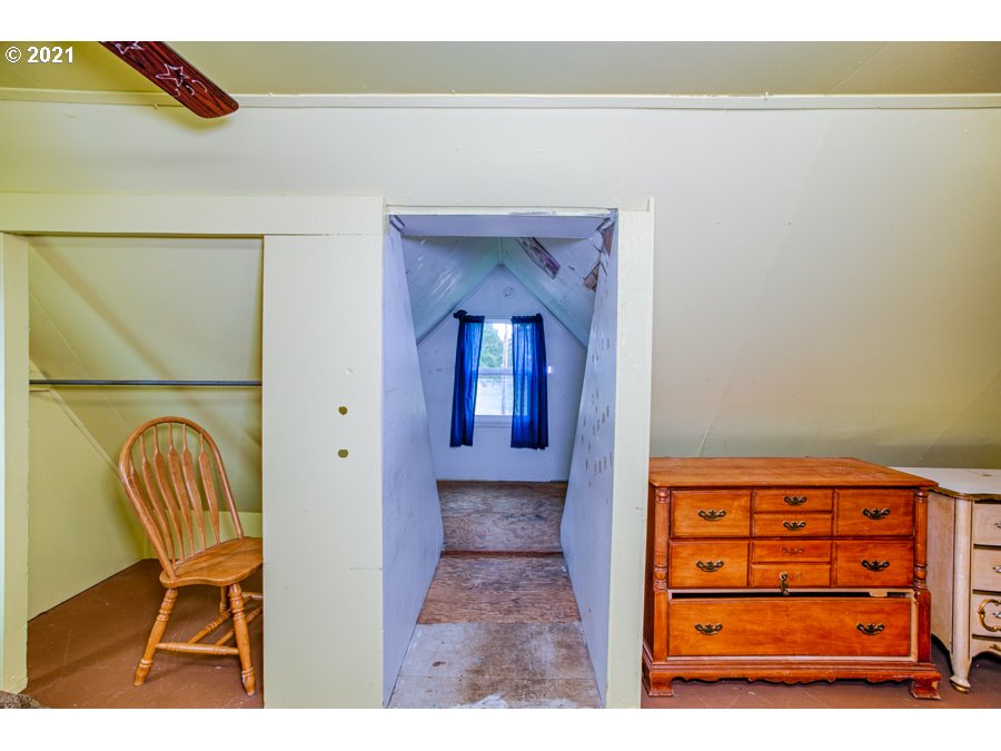 7701 Howell Prairie Road Northeast Silverton, OR 97381 - Photo 10 of 19 a view of a hallway with a chair and a potted plant on a dresser