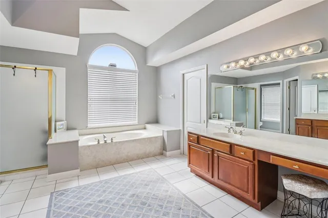 a spacious bathroom with a tub sink and mirror