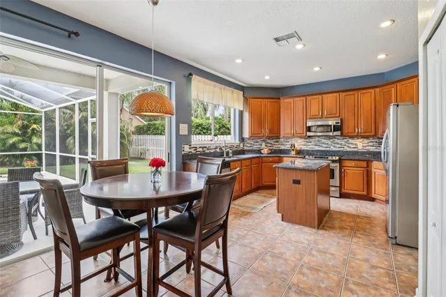 a kitchen with stainless steel appliances granite countertop a stove a sink a microwave dining table and chairs