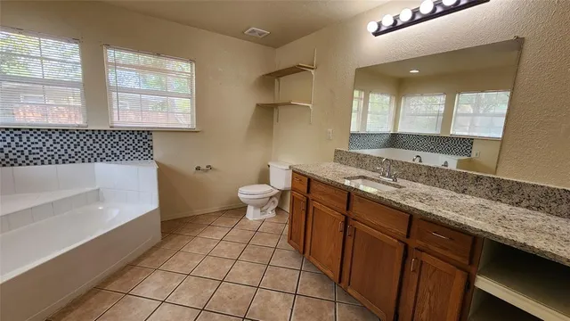 a bathroom with a granite countertop sink toilet and bathtub