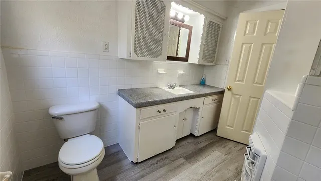 a spacious bathroom with a granite countertop toilet a sink and a mirror