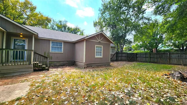 a view of backyard of house with green space