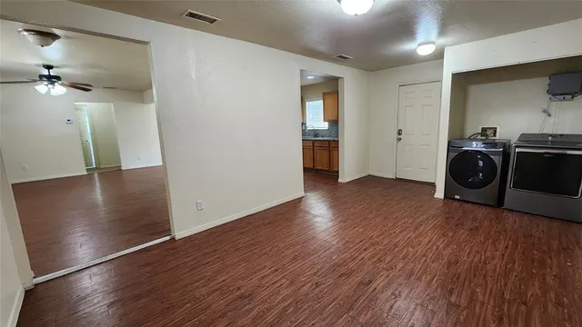 an empty room with wooden floor and entrance