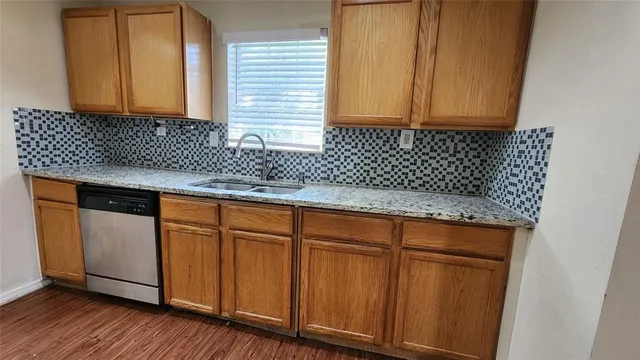 a kitchen with stainless steel appliances granite countertop wooden cabinets a sink and dishwasher