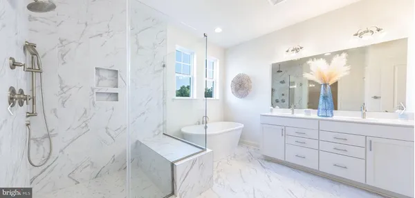 a spacious bathroom with a double vanity sink toilet mirror and bathtub