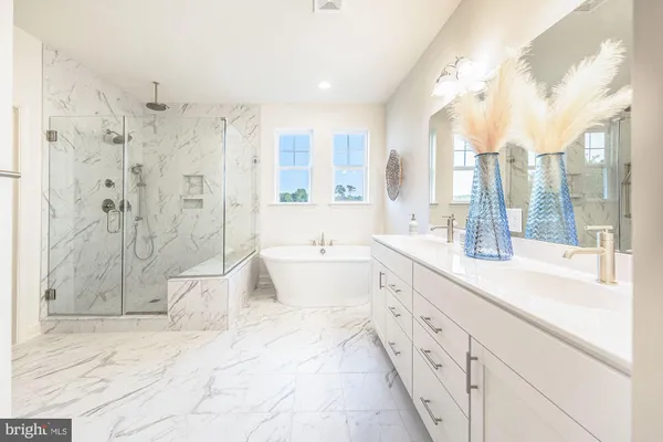 a spacious bathroom with a double vanity sink toilet mirror and bathtub