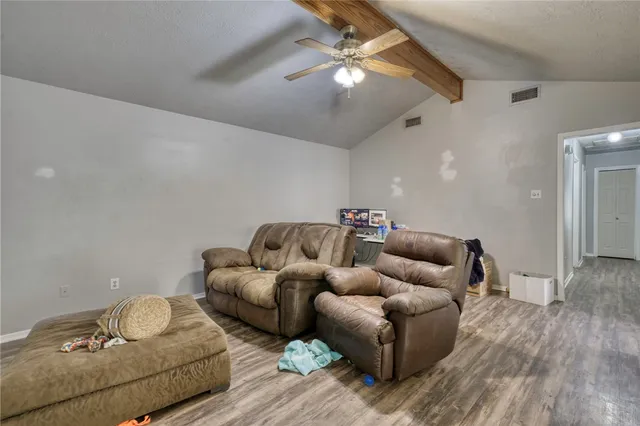 a living room with furniture and a wooden floor