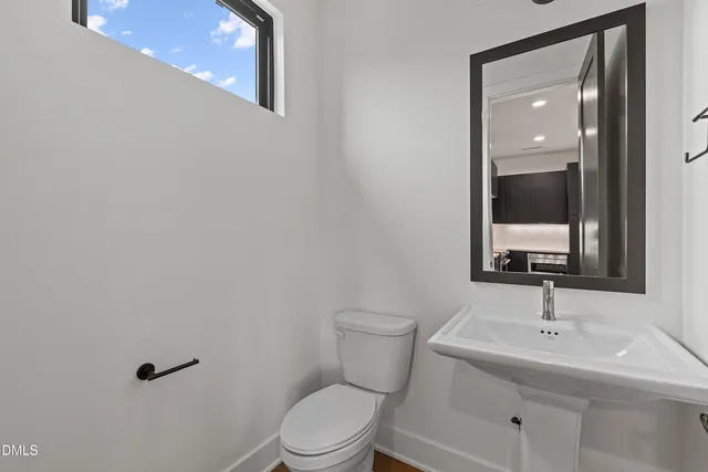 a bathroom with a toilet a sink and mirror
