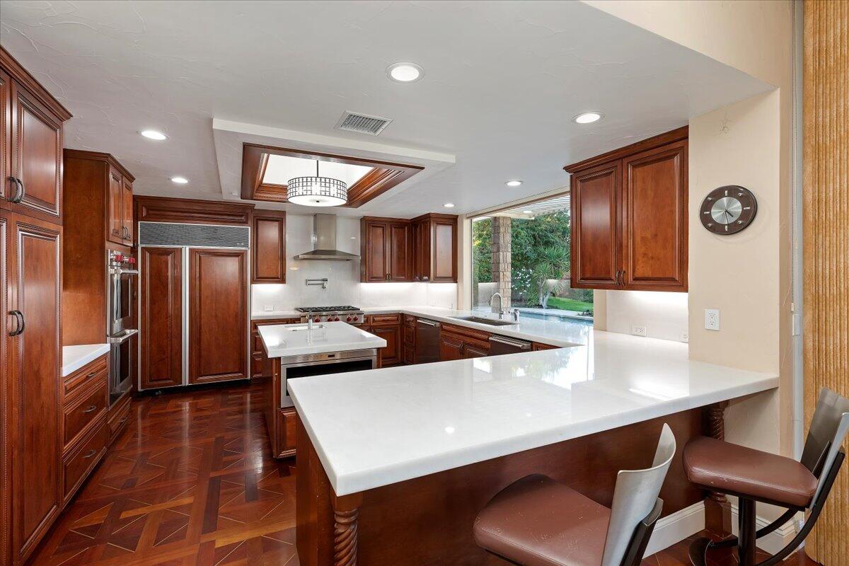 2 Deerfield Court Rancho Mirage, CA 92270 - Photo 33 of 104 a kitchen with stainless steel appliances granite countertop a dining table chairs refrigerator and sink