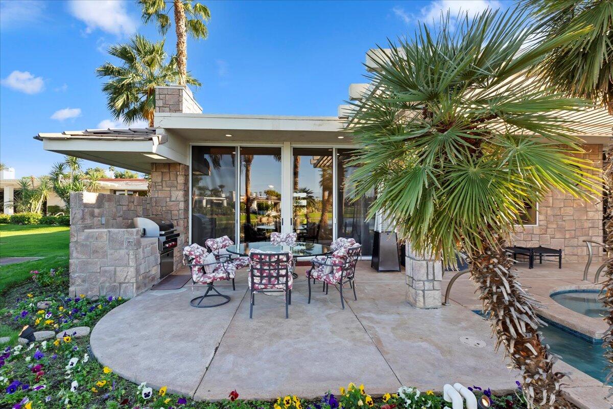 2 Deerfield Court Rancho Mirage, CA 92270 - Photo 71 of 104 a view of a patio with table and chairs potted plants and palm trees
