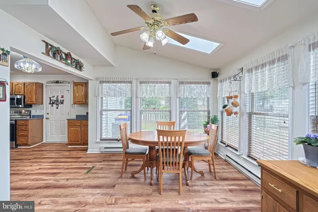 a dining room with furniture a chandelier and wooden floor
