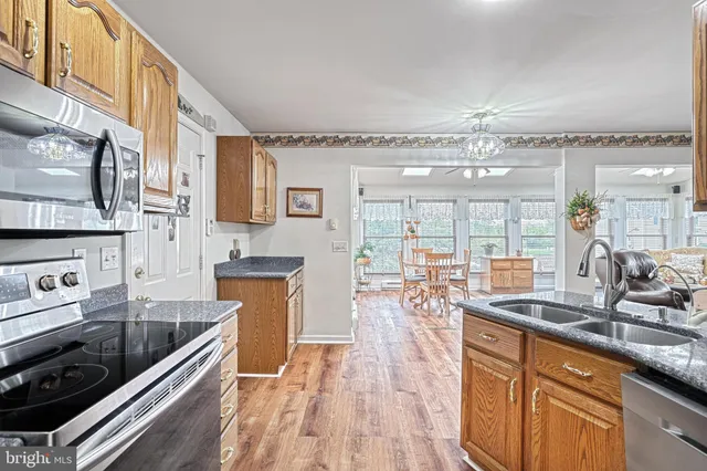 a kitchen with stainless steel appliances granite countertop a lot of counter space and wooden floors