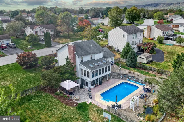 an aerial view of a house with a yard and a large tree
