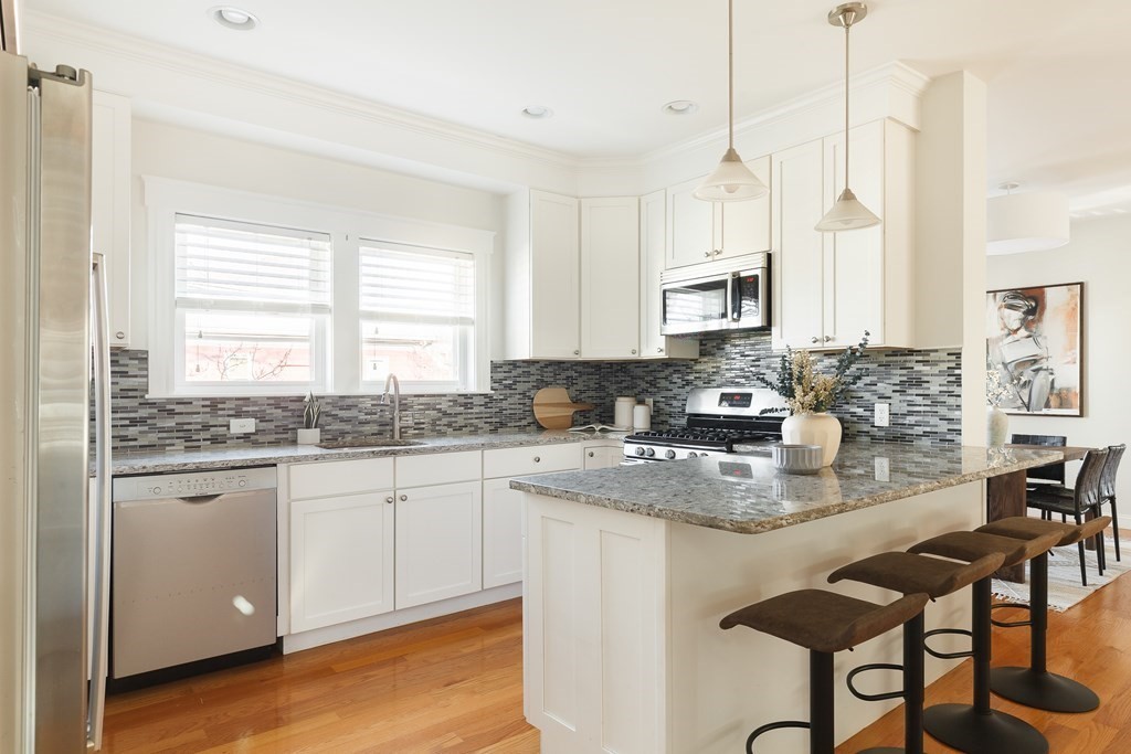 32 Cedar Street, Unit 2 Somerville, MA 02143 - Photo 9 of 20 a kitchen with stainless steel appliances granite countertop a stove a sink and a refrigerator