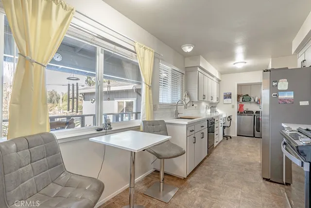 a large white kitchen with a large window