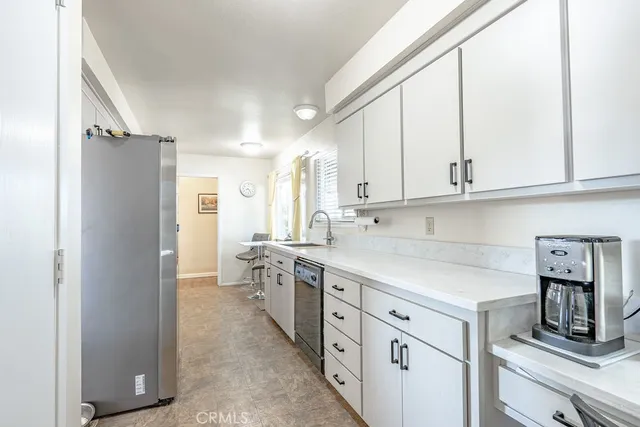 a kitchen with stainless steel appliances white cabinets and a refrigerator