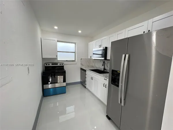 a kitchen with white cabinets and white appliances