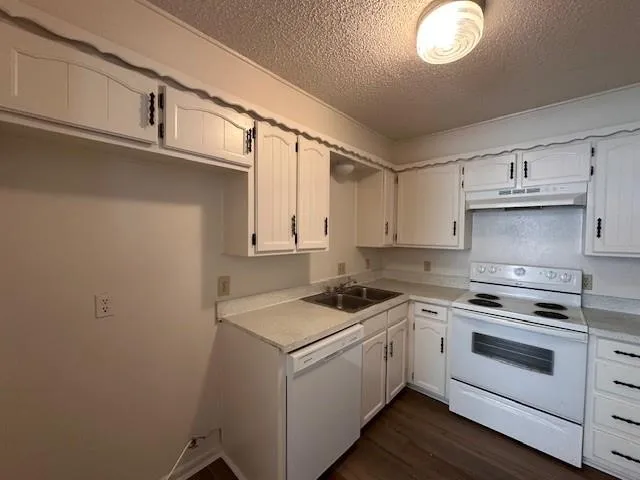 a kitchen with cabinets appliances a sink and a counter top