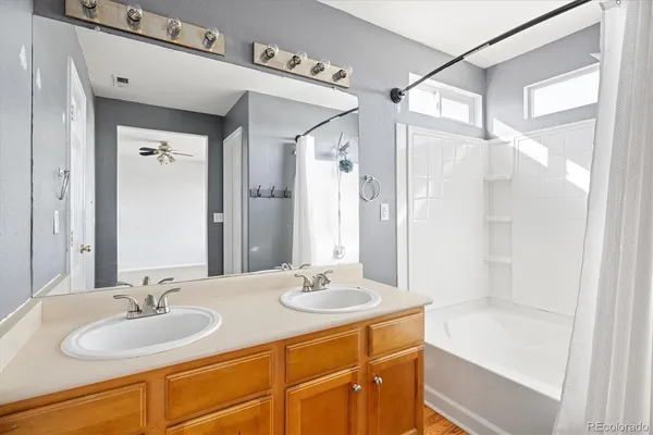 a bathroom with a granite countertop sink mirror and a bathtub
