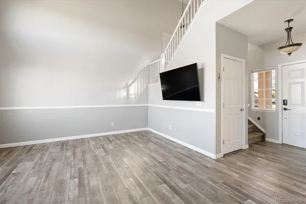 a view of a livingroom with wooden floor and a flat screen tv