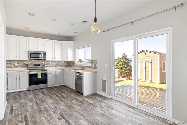 a kitchen with white cabinets and white appliances