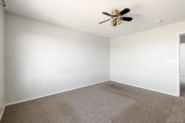 an empty room with a ceiling fan and a window