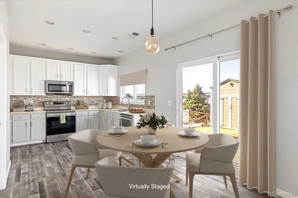 a kitchen with stainless steel appliances kitchen island granite countertop a stove a sink a refrigerator dining table and chairs