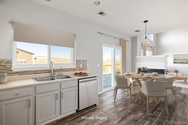 a kitchen with a sink dining table and chairs