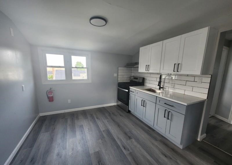 123 Prospect Street, Unit 2 Roselle, NJ 07203 - Photo 8 of 9 a kitchen with stainless steel appliances white cabinets and wooden floors