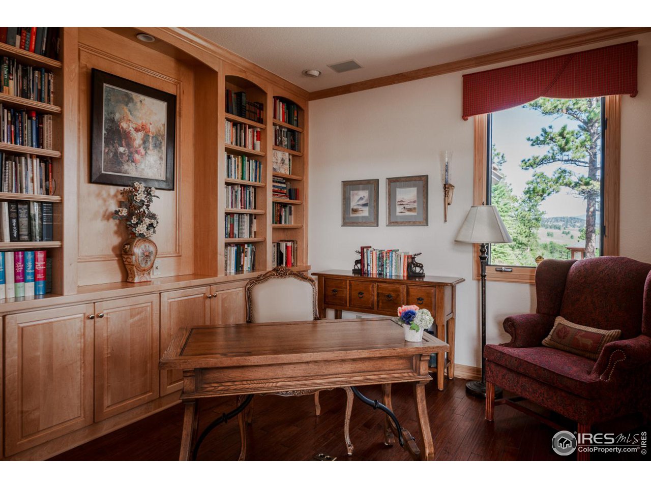 2964 Elk View Drive Evergreen, CO 80439 - Photo 22 of 40 a living room with furniture a bookshelf and a window