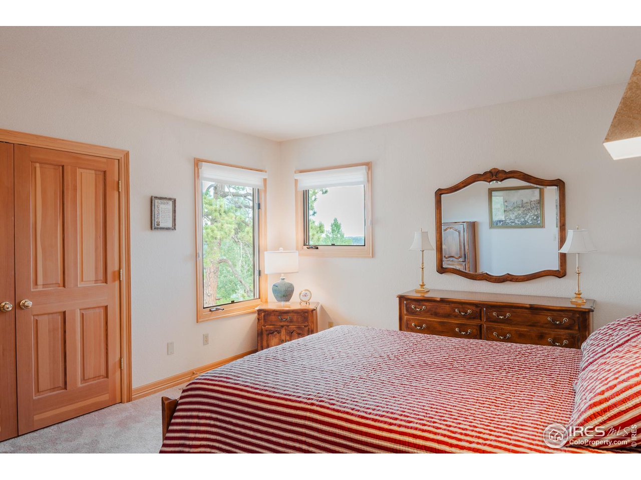 2964 Elk View Drive Evergreen, CO 80439 - Photo 29 of 40 a bedroom with a bed a dresser and a window