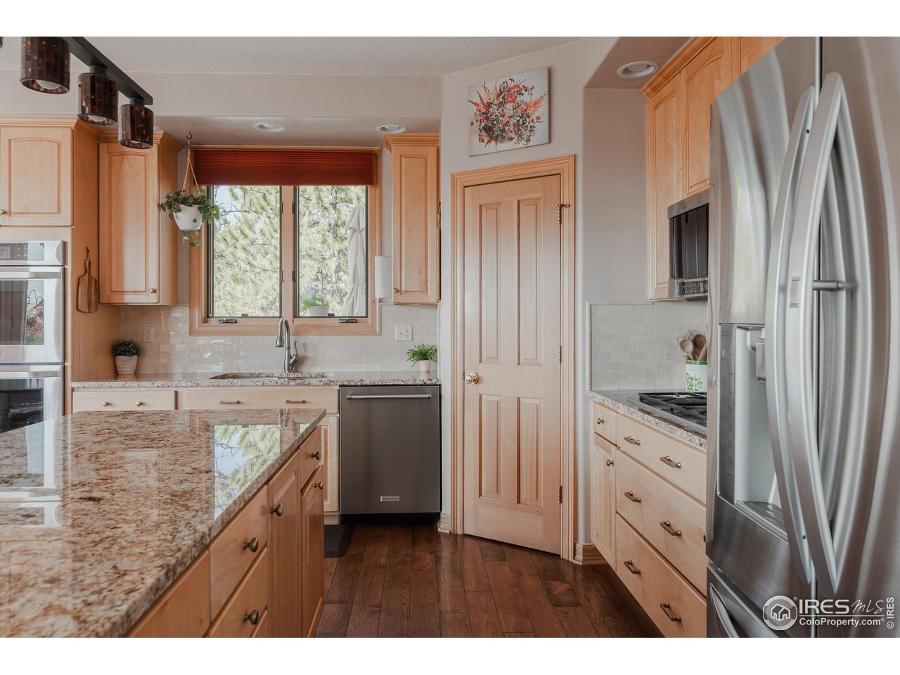 2964 Elk View Drive Evergreen, CO 80439 - Photo 8 of 40 a kitchen with stainless steel appliances granite countertop a refrigerator a sink and white cabinets