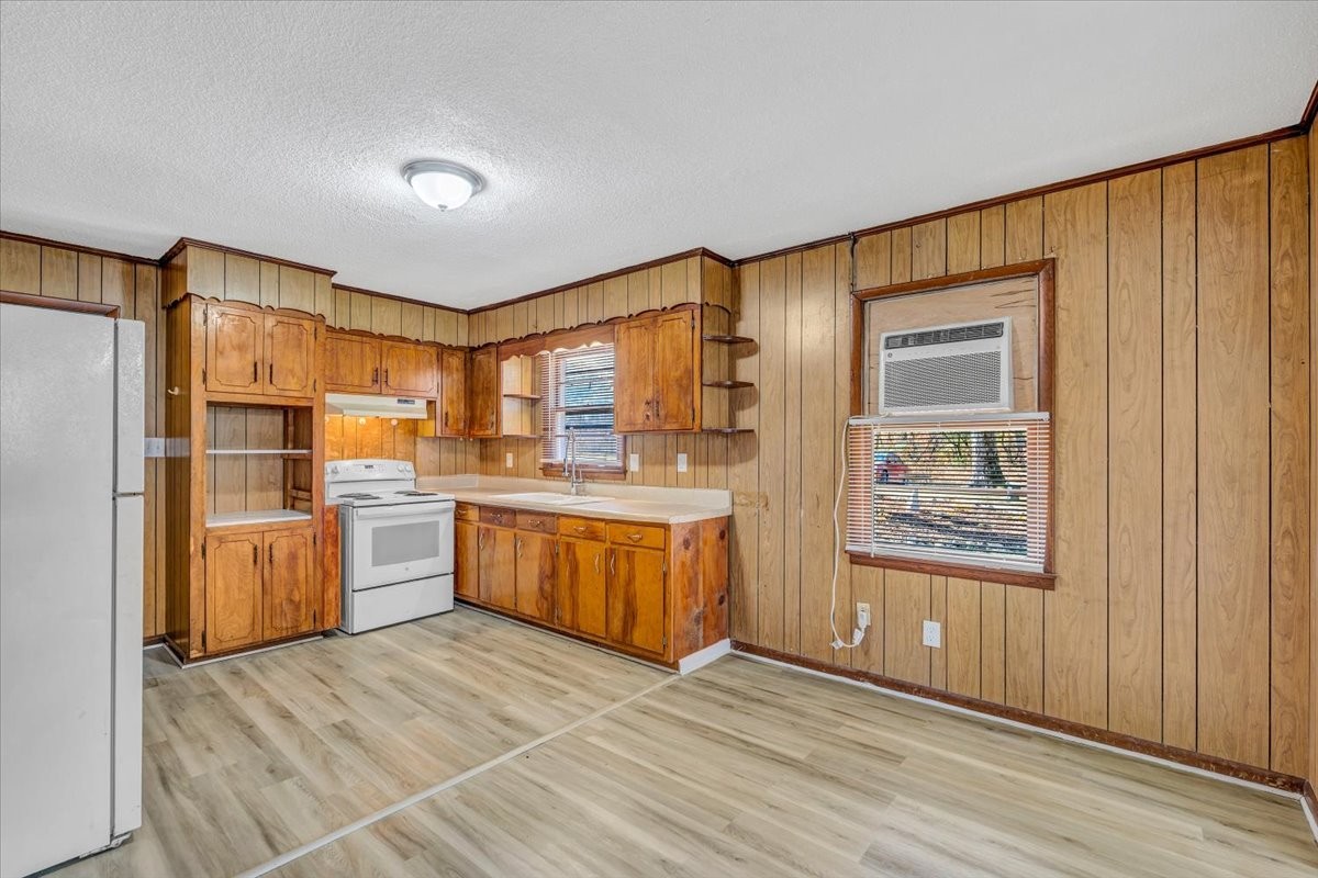 390 Junus Jackson Hollow Road Minor Hill, TN 38473 - Photo 13 of 38 a kitchen with stainless steel appliances granite countertop a refrigerator a sink dishwasher and wooden cabinets with wooden floor