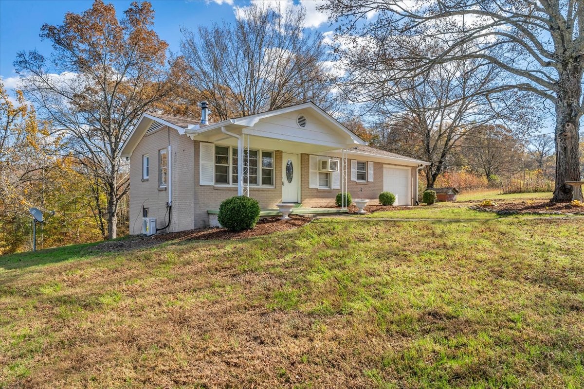 390 Junus Jackson Hollow Road Minor Hill, TN 38473 - Photo 2 of 38 a front view of a house with a garden