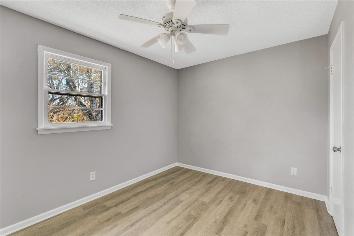 390 Junus Jackson Hollow Road Minor Hill, TN 38473 - Photo 22 of 38 a view of empty room with wooden floor and ceiling fan