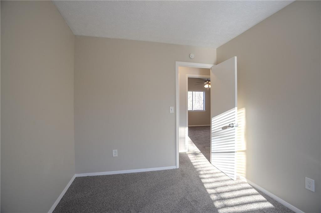 5449 Martins Crossing Road Stone Mountain, GA 30088 - Photo 13 of 32 a view of a hallway with wooden cabinets and stairs