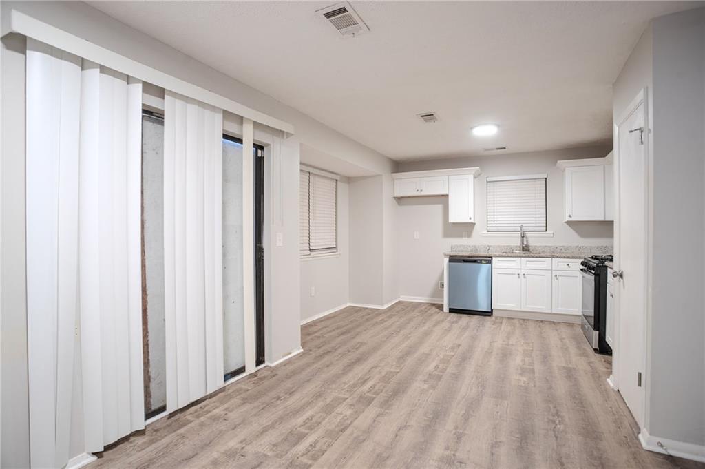 5449 Martins Crossing Road Stone Mountain, GA 30088 - Photo 6 of 32 a kitchen with stainless steel appliances a refrigerator sink and cabinets