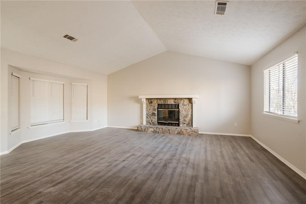 5449 Martins Crossing Road Stone Mountain, GA 30088 - Photo 7 of 32 a view of empty room with wooden floor and fireplace