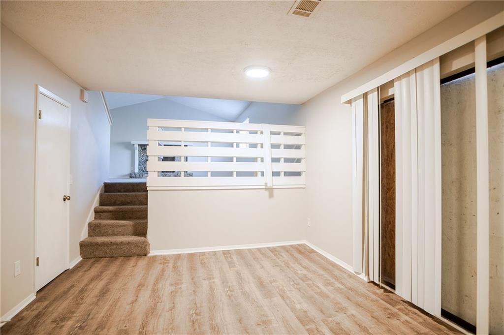 5449 Martins Crossing Road Stone Mountain, GA 30088 - Photo 10 of 32 wooden floor in an empty room with a window